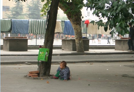 他身后的篮球场就是妈妈工作的地方